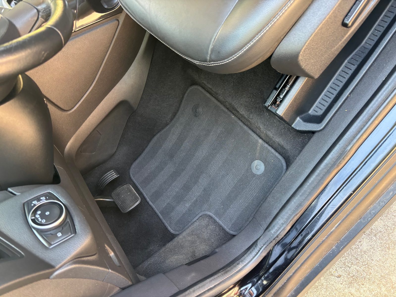 The same Ford Escape footwell after an interior detail — carpet and mats fully cleaned