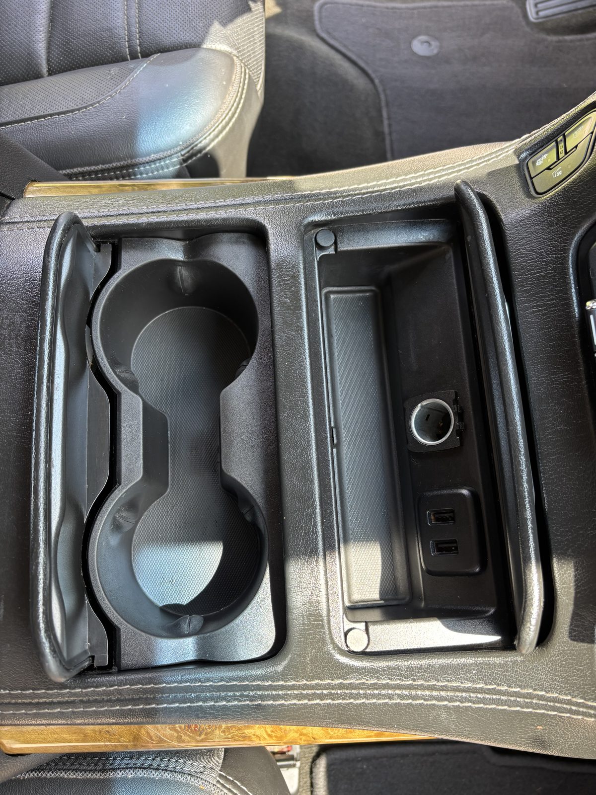 The same GMC Yukon Denali console and cup holders after an interior detail