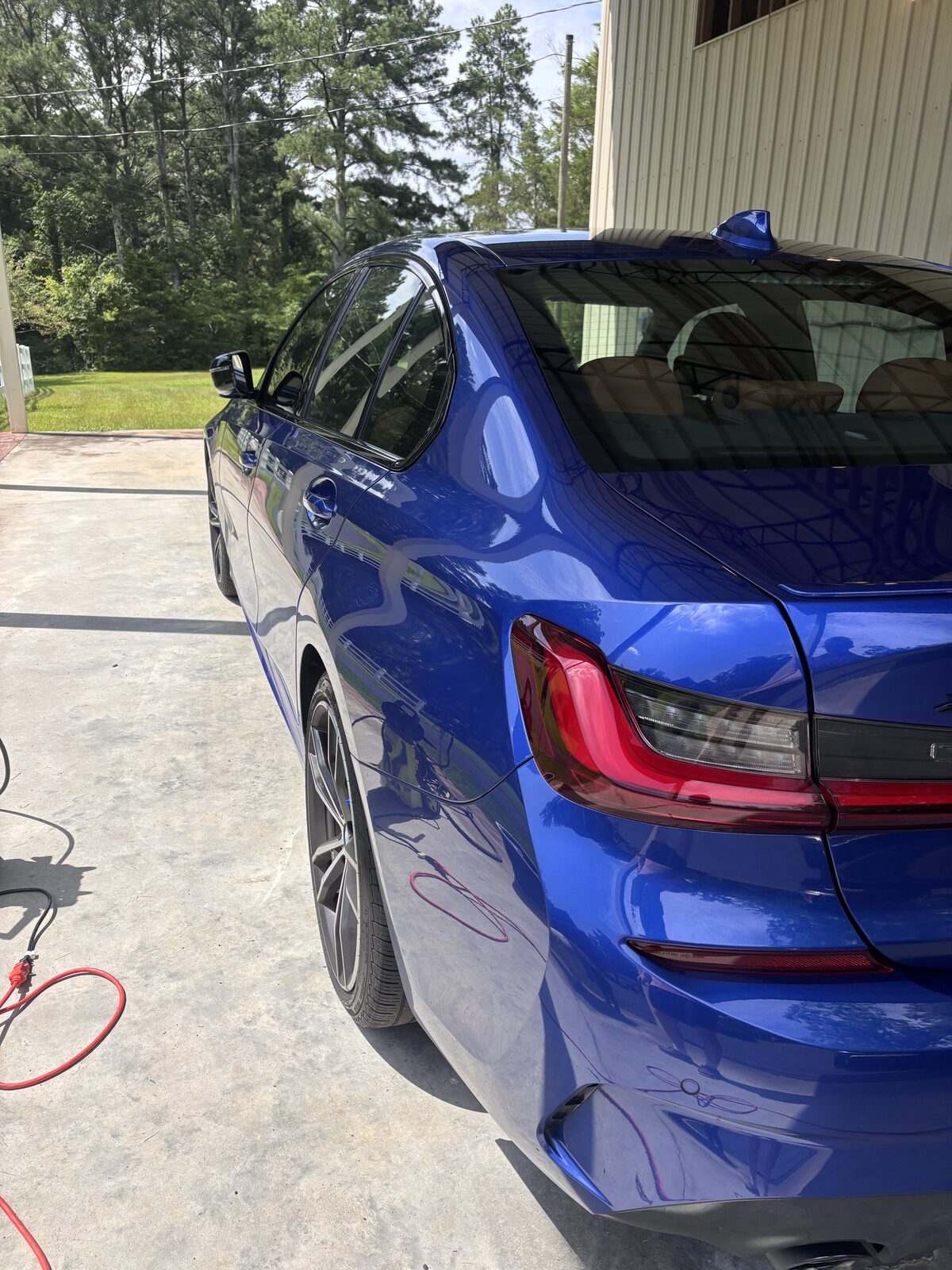 Deep gloss on the rear quarter panel of a blue BMW 3 Series after detail